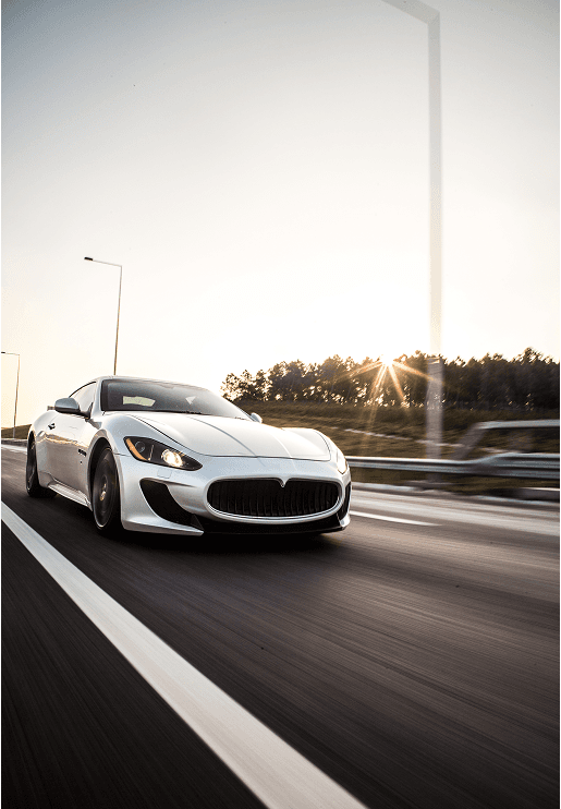 Luxury white sports car driving on a scenic road